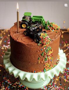 a chocolate cake with sprinkles and a tractor on top