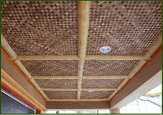 the inside of a building with wood and wicker covering it's roof area