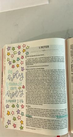 an open bible with colorful stars on the pages and words written in different languages,