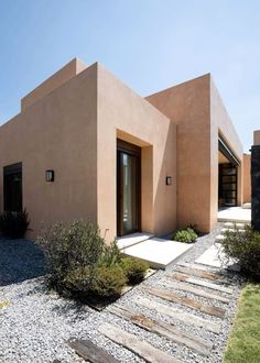 a house that is in the middle of some rocks and gravel with stairs leading up to it