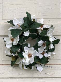 a wreath with white flowers and green leaves