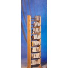 a tall wooden book shelf with many books on it's sides and several dvds in the shelves