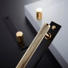 a close up of a metal object on a black surface with two gold knobs