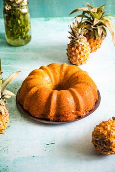 pineapple bundt cake on a plate surrounded by pineapples and mason jars