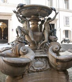 a fountain with birds on it in front of a building