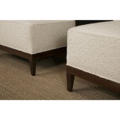 two white upholstered chairs sitting next to each other on a carpeted floor