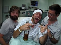 three men laughing and drinking beer in a hospital room