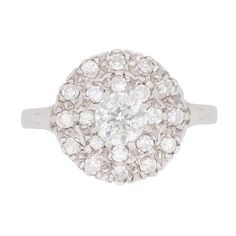 This beautiful cluster ring has a 0.50 carat centre stone which is an Old Cut. It is highlighted by eight cut diamonds totalling 0.40 carat and are grain set. The centre stone is claw set in a handcrafted platinum band, which compliments the G colour diamonds. The clean cut elegance to this ring is lovely and it works well with a variety of wedding bands. Gemstone: Diamond Stone Shape: Old Cut Carat Weight: 0.50 centre Colour: G Clarity: SI Metal: Platinum Age: 1920s Size: P 1920s Engagement Ring Vintage, 1920s Engagement Ring, Filigree Ring Gold, Stunning Diamond Rings, Engagement Rings Twisted, Filigree Engagement Ring, Edwardian Jewelry, Platinum Diamond Rings, White Gold Set