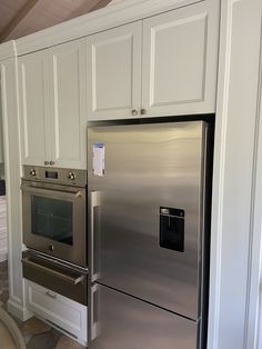 a metallic refrigerator freezer sitting inside of a kitchen