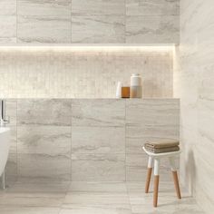 a white bath tub sitting next to a wooden stool