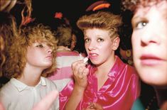 a group of young women standing next to each other in front of a man brushing his teeth