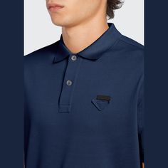 Prada polo in pique knit with tone-on-tone triangle logo on the chest. Approx. 27.5"L from shoulder to hem. Spread collar; two-button placket. Short sleeves. Slim fit. Vented hem. Pullover style. Cotton. Made in Romania. Navy Formal Polo Shirt, Luxury Blue Collared Polo Shirt, Designer Collared Polo Shirt For Formal Occasions, Luxury Navy Polo Shirt, Luxury Business Polo Collar Tops, Luxury Business Tops With Polo Collar, Luxury Formal Polo Shirt, Modern Polo Shirt With Polo Collar For Business, Modern Polo Shirt For Business