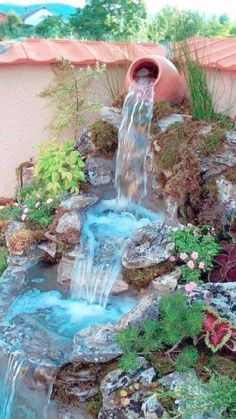 a small waterfall in the middle of a garden