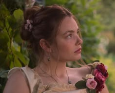 a woman with flowers in her hair is looking off into the distance while wearing a dress