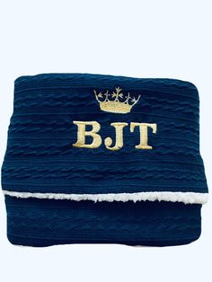 a blue blanket with a gold bltt on it and a crown in the middle