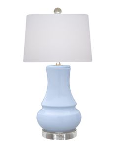 a light blue lamp with a white shade on it's side and a silver base