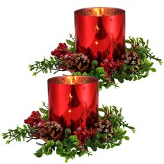 two red candles with pine cones and berries