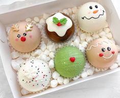 a box filled with different types of decorated donuts