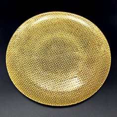 a gold plate sitting on top of a black table