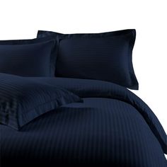 a bed with blue comforters and pillows on top of it, in front of a white background