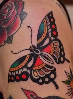 a woman's arm with tattoos on it and a butterfly, roses and butterflies