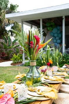 a long table with plates and flowers on it