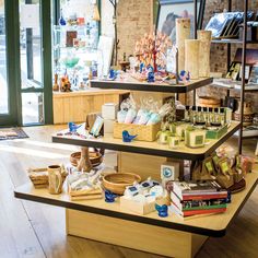 three tiered display in a store filled with lots of goods and items on wooden shelves