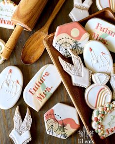 decorated cookies are sitting on a tray next to wooden spoons and cookie cutters