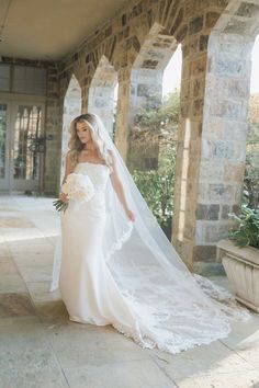 a woman in a wedding dress is posing for the camera with her veil over her head