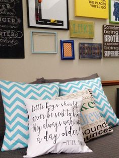 a bed topped with lots of pillows and pictures on the wall