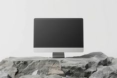 a computer monitor sitting on top of a rock