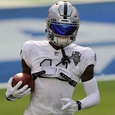 a football player holding a ball on the field