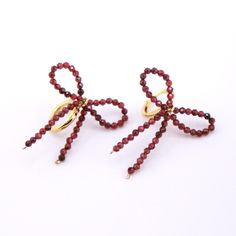 two pairs of red beaded scissors on white background