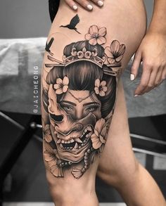 a woman's thigh with tattoos and flowers on her head, in the shape of a skull