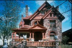 an old brick house with a porch and balconies