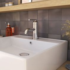 a white sink sitting under a bathroom mirror next to a shelf with bottles on it