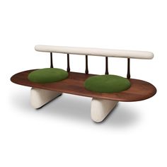 a wooden bench with two green pillows on it's back end and three white legs