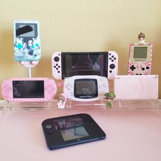 several nintendo wii game systems sitting on top of a pink table next to each other