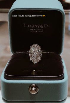 an engagement ring in a blue box with the words tiffany & co written on it