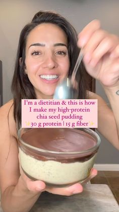 a woman holding a spoon in front of a bowl with chocolate and cream on it