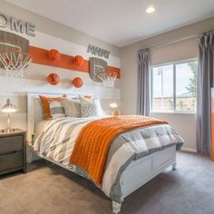 a bedroom decorated in orange and gray with basketballs on the wall