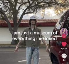 a man standing next to a red car with the words i am just a museum of everything i've loved