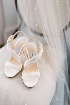 the bride's shoes are sitting on her wedding day chair, which is covered in veils