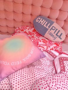 a bed with pink and red pillows on top of it next to a pillow that says, you don't need another pillow