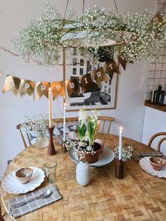 a dining room table with flowers and candles on it, decorated for a birthday party