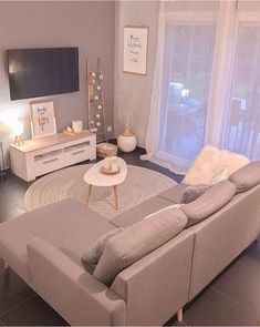 a living room filled with furniture and a flat screen tv on top of a wall