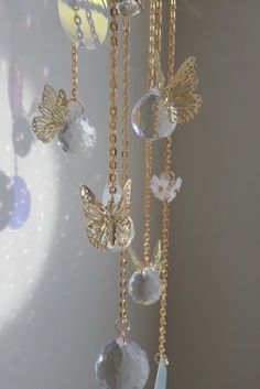 a wind chime with butterflies hanging from it's sides and crystal beads attached to the chain