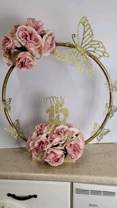 pink flowers are in the middle of a gold wreath