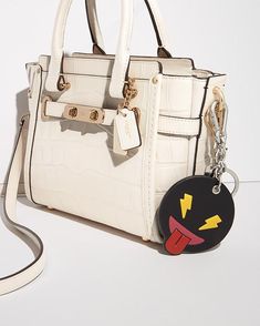 Hand-worked leather meets a motif of the times in this playful modern design. Dress up your favorite Coach bag with this mischievous emoji character, or carry your keys with a dash of attitude. Leather 2 3/4" (L) x 3 1/4" (H) 1 1/4" attached split key ring and carabiner clip Style No: 65833 Imported Mischievous Emoji, Emoji Bag, Emoji Characters, Good Face, Carabiner Clip, Design Dress, Coach Bag, Color Plata, Interesting Faces