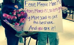 two women holding flowers and a sign